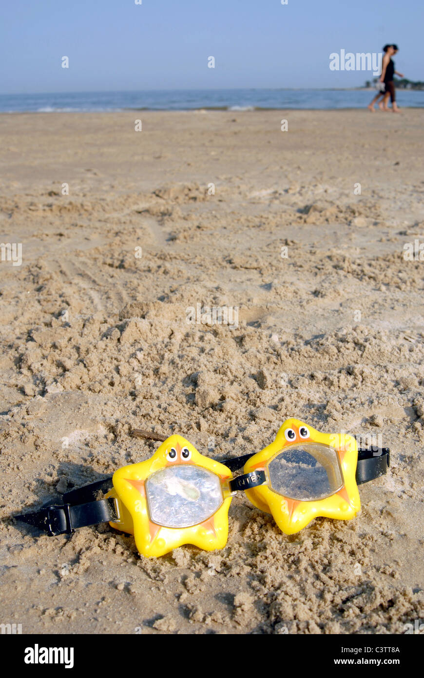 Toy swimming glasses star shaped on the sand. Stock Photo