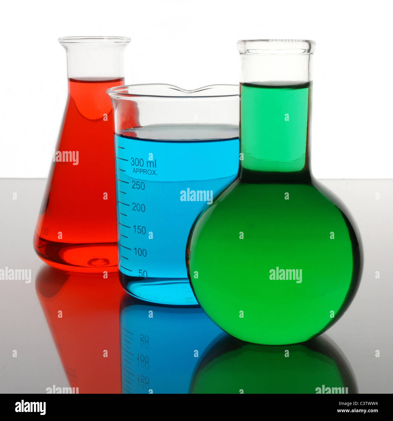 laboratory beaker and flasks containing red, blue, green liquids Stock Photo