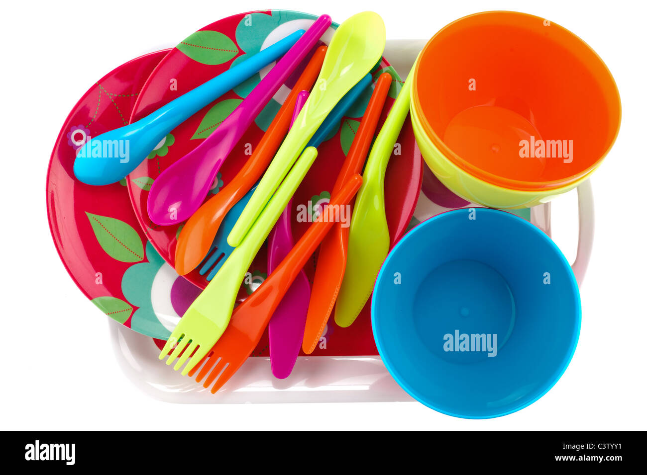 Pile of coloured plastic cutlery plates and dishes on a plastic tray Stock Photo