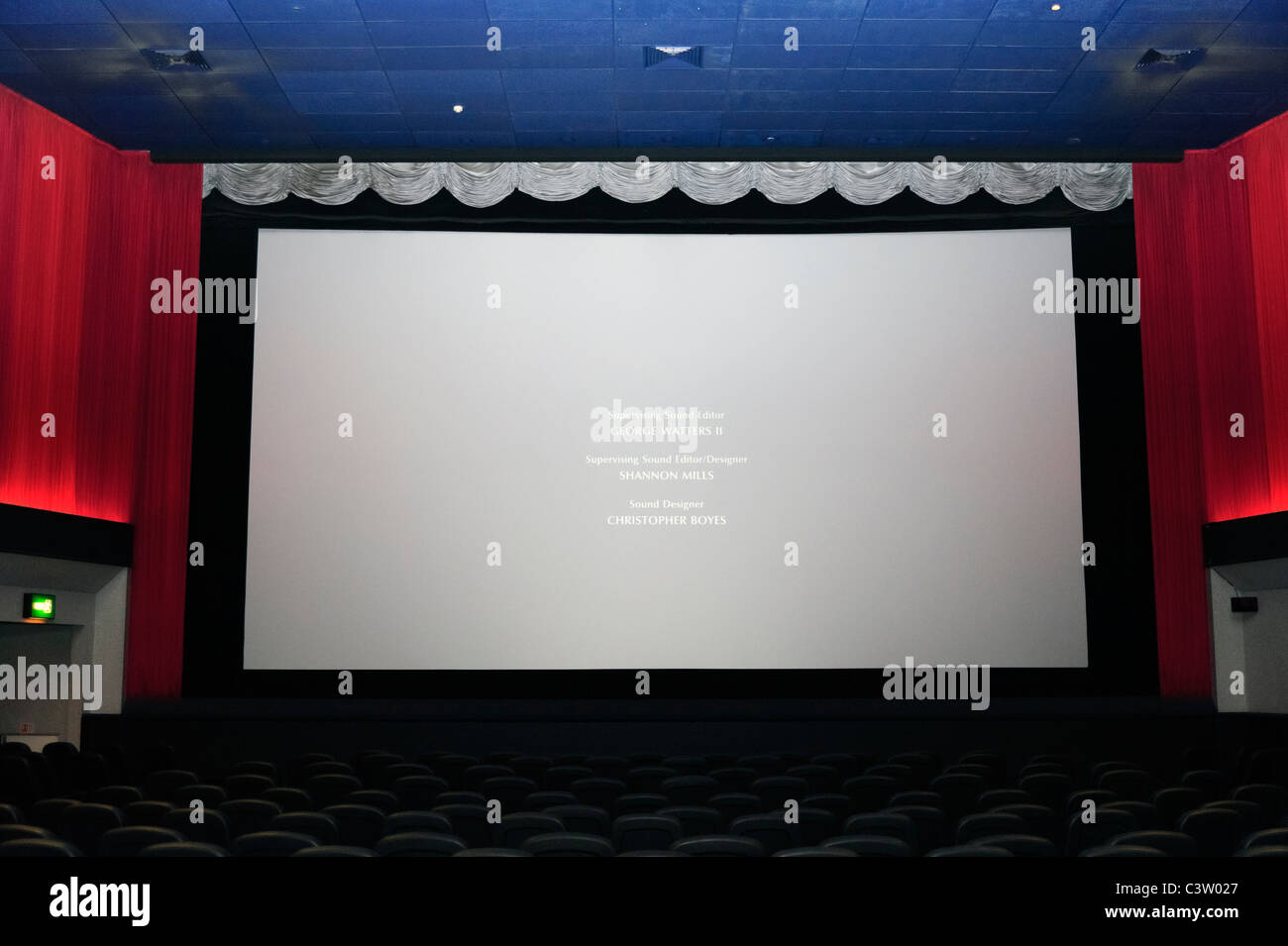 Interior of cinema showing empty screen with rolling credits at the end of a film, Gloucester, UK. Stock Photo