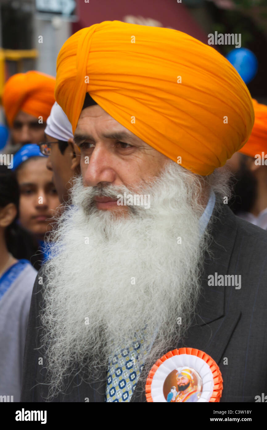 Bearded Sikh in orange turban marching in the 2011 Sikh Day parade in New York City Stock Photo