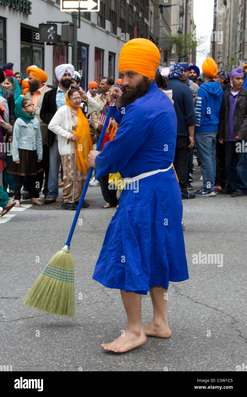 A barefoot male Sikh engaged  in a symbolic sweeping of Madison Avenue before the 2011 Sikh Day parade begins Stock Photo