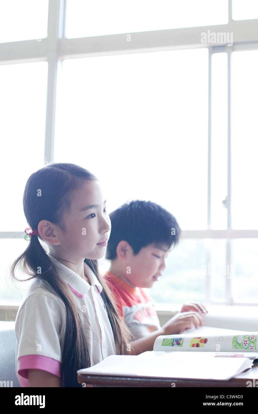 Schoolgirl Listening in Classroom Stock Photo