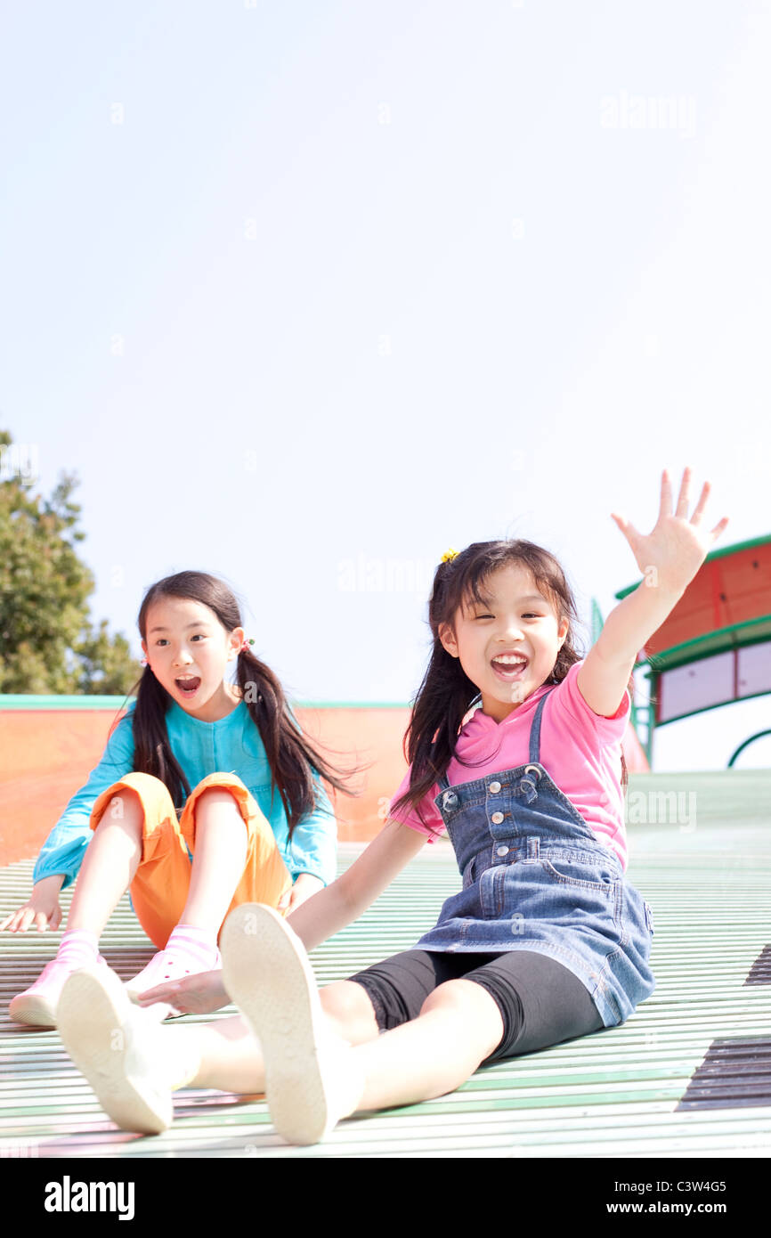 Two Girls on Slide Stock Photo - Alamy