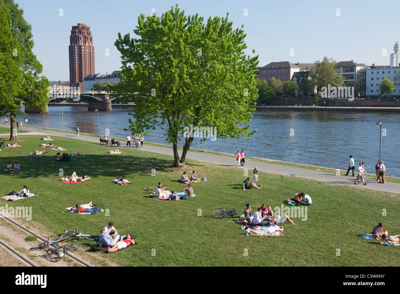 People relaxing by the river Main in Frankfurt, Germany on a warm late Spring day. Stock Photo