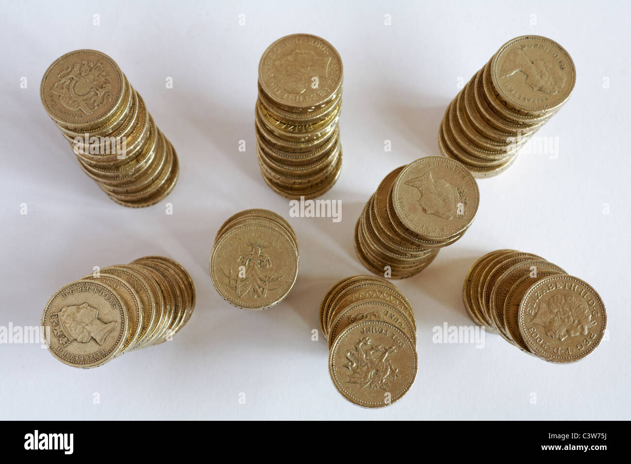 looking down on piles of one pound coins set on white background Stock Photo