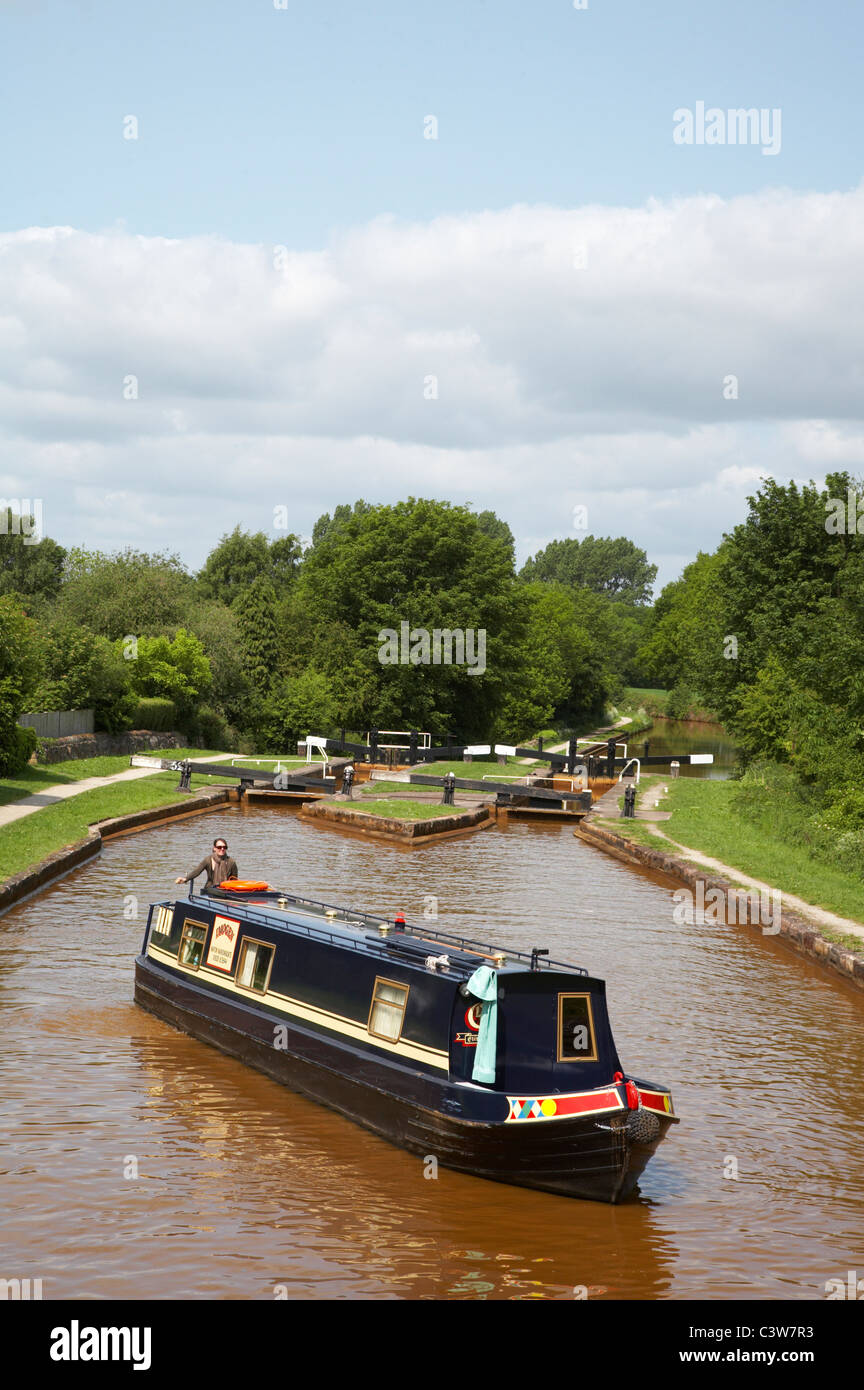 Narrow boat on the Trent and Mersey canal with Lawton Locks Cheshire UK Stock Photo