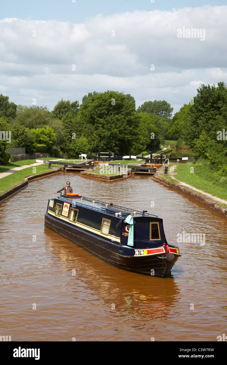 Narrow boat on the Trent and Mersey canal with Lawton Locks Cheshire UK Stock Photo