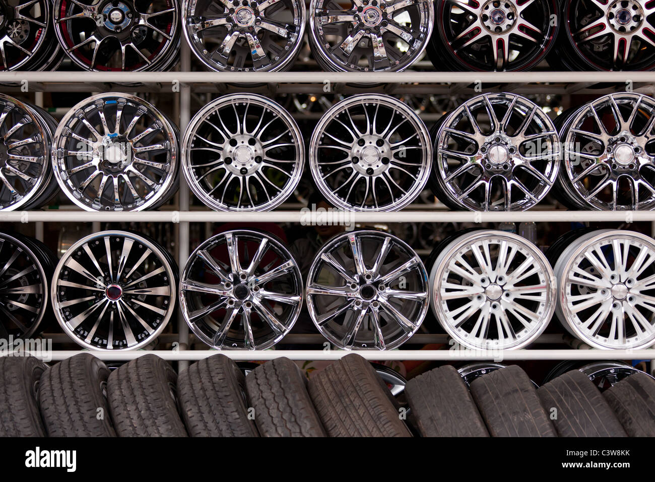 wall of alloy car wheels and pneumatic tires in store Stock Photo