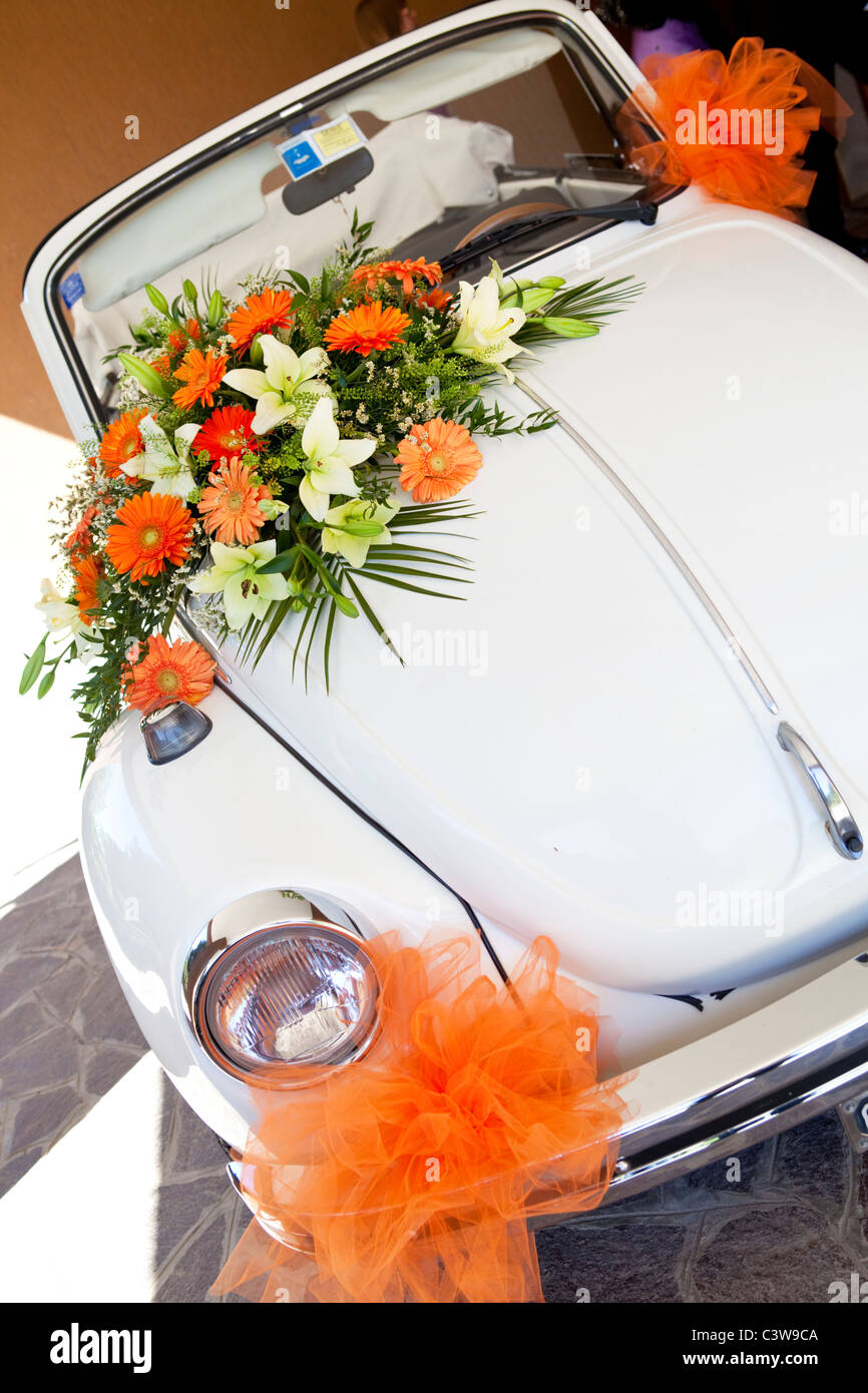 VW Volkswagen maggiolone wedding car decorated with orange flowers Stock Photo