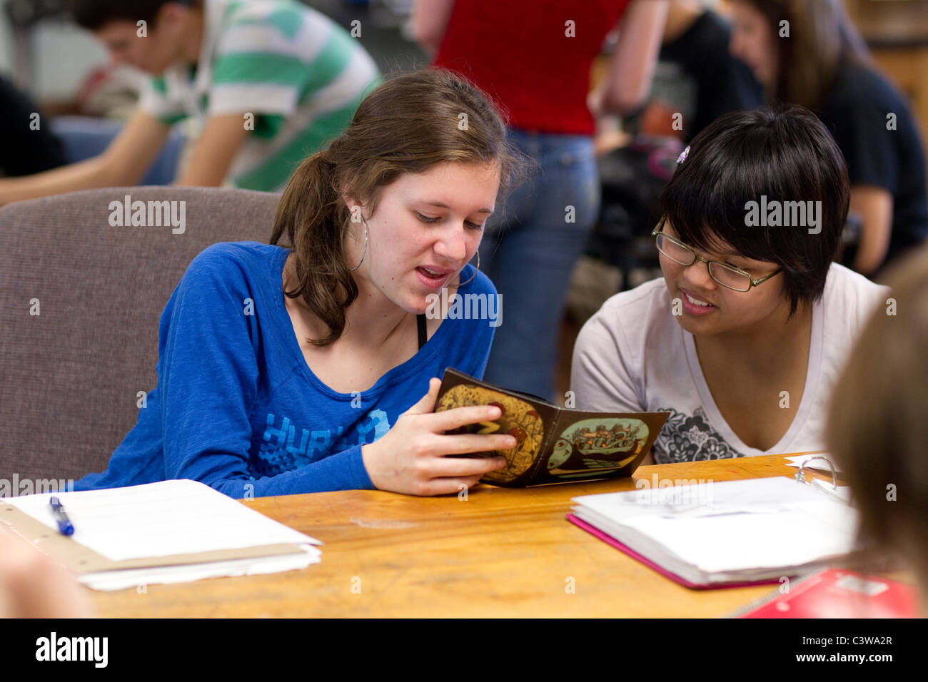 Anglo and Asian girls collaborate on assignment in class at Rapoport