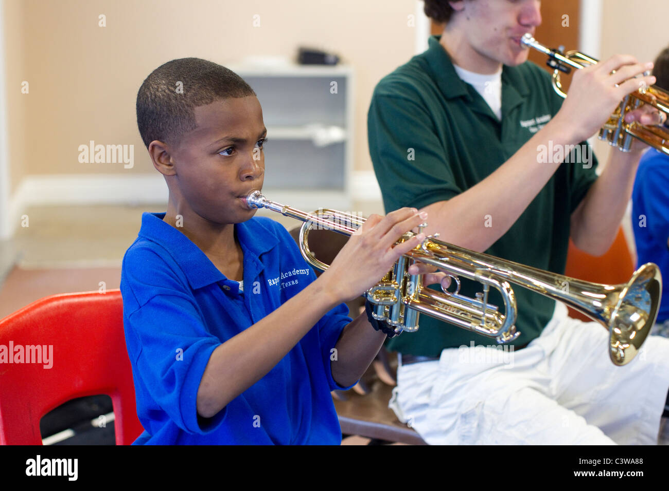 African-American and Anglo male middle school students play trumpets ...