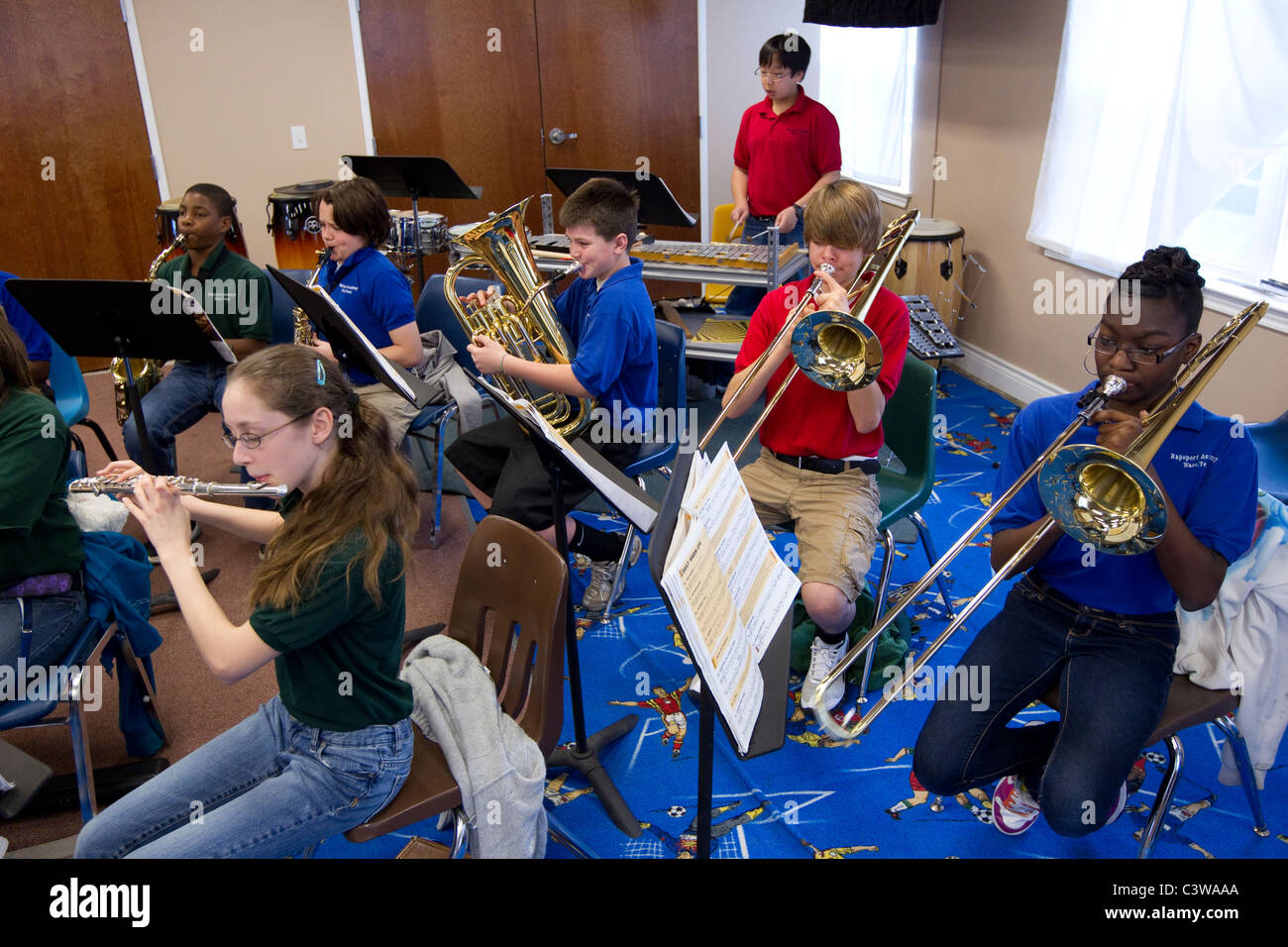Anglo, Hispanic and African-American middle school students play wind and brass instruments during orchestra class Stock Photo