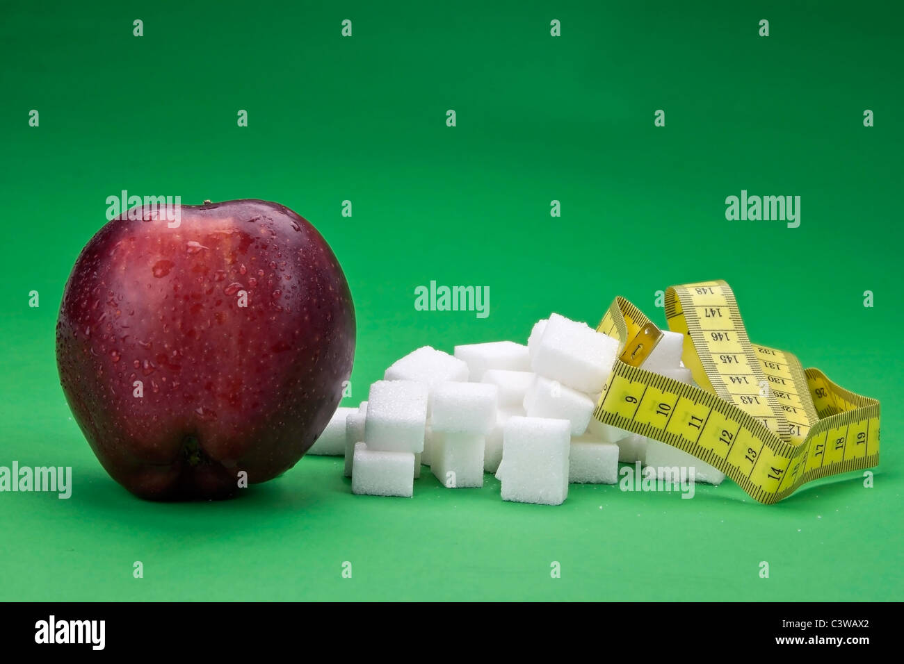 an apple against sugar cubes - healthy versus unhealthy Stock Photo