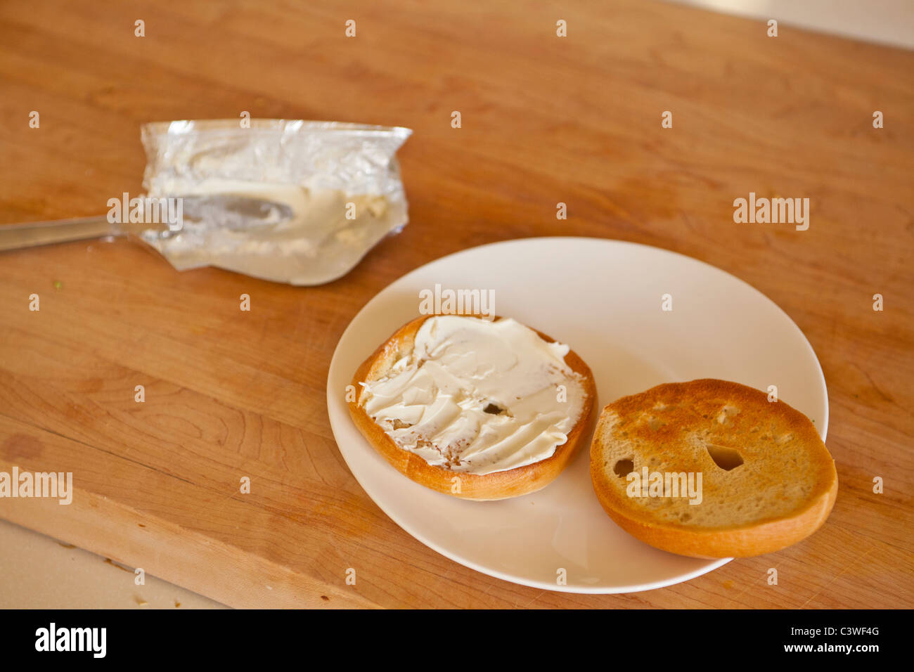A toasted bagel with cream cheese Stock Photo