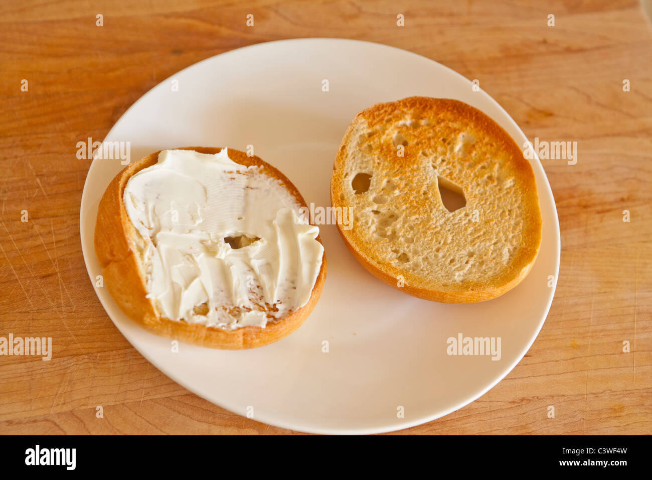 A toasted bagel with cream cheese Stock Photo