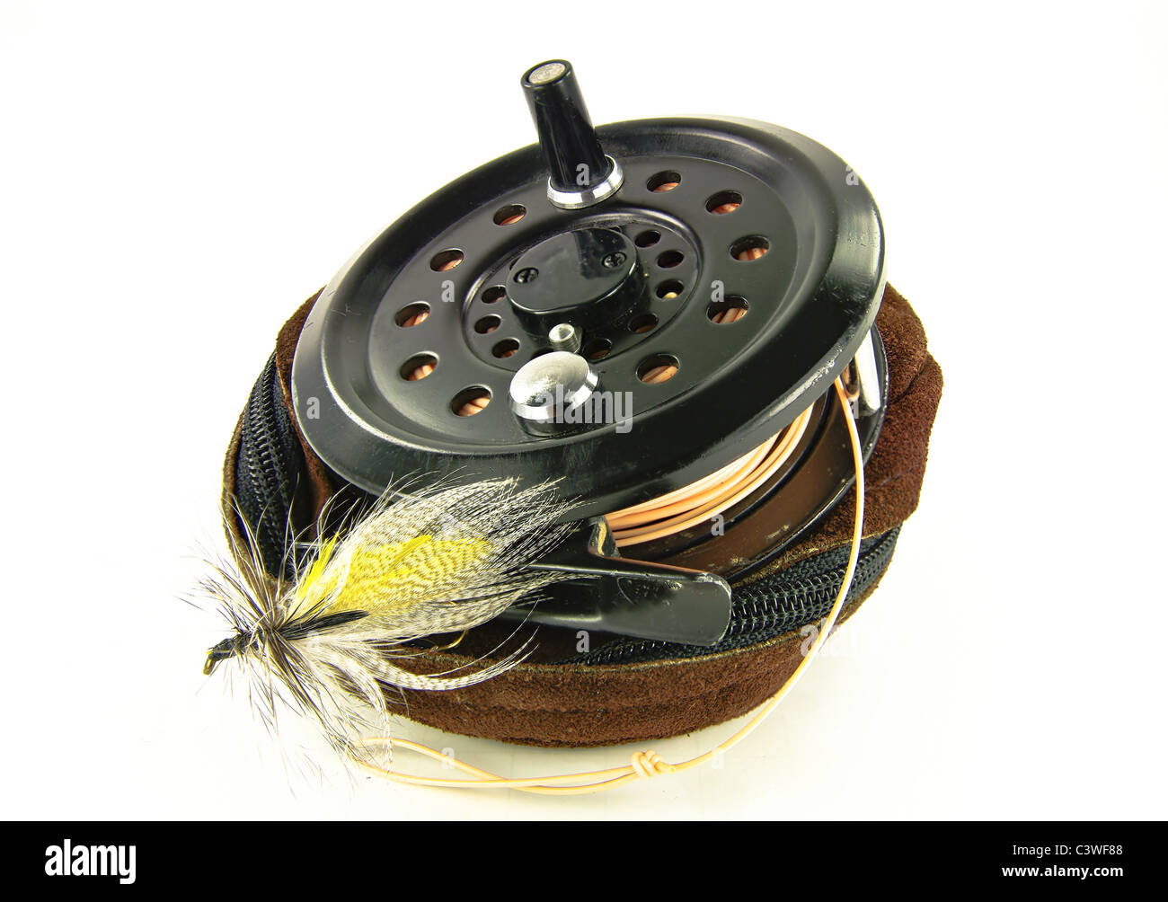 Fly Fishing Reel: A well-used fishing reel sits atop its leather case along  with a lure made for fly-fishing Stock Photo - Alamy