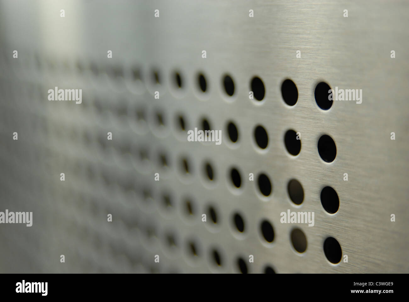 Aligned perforations on metallic surface Stock Photo