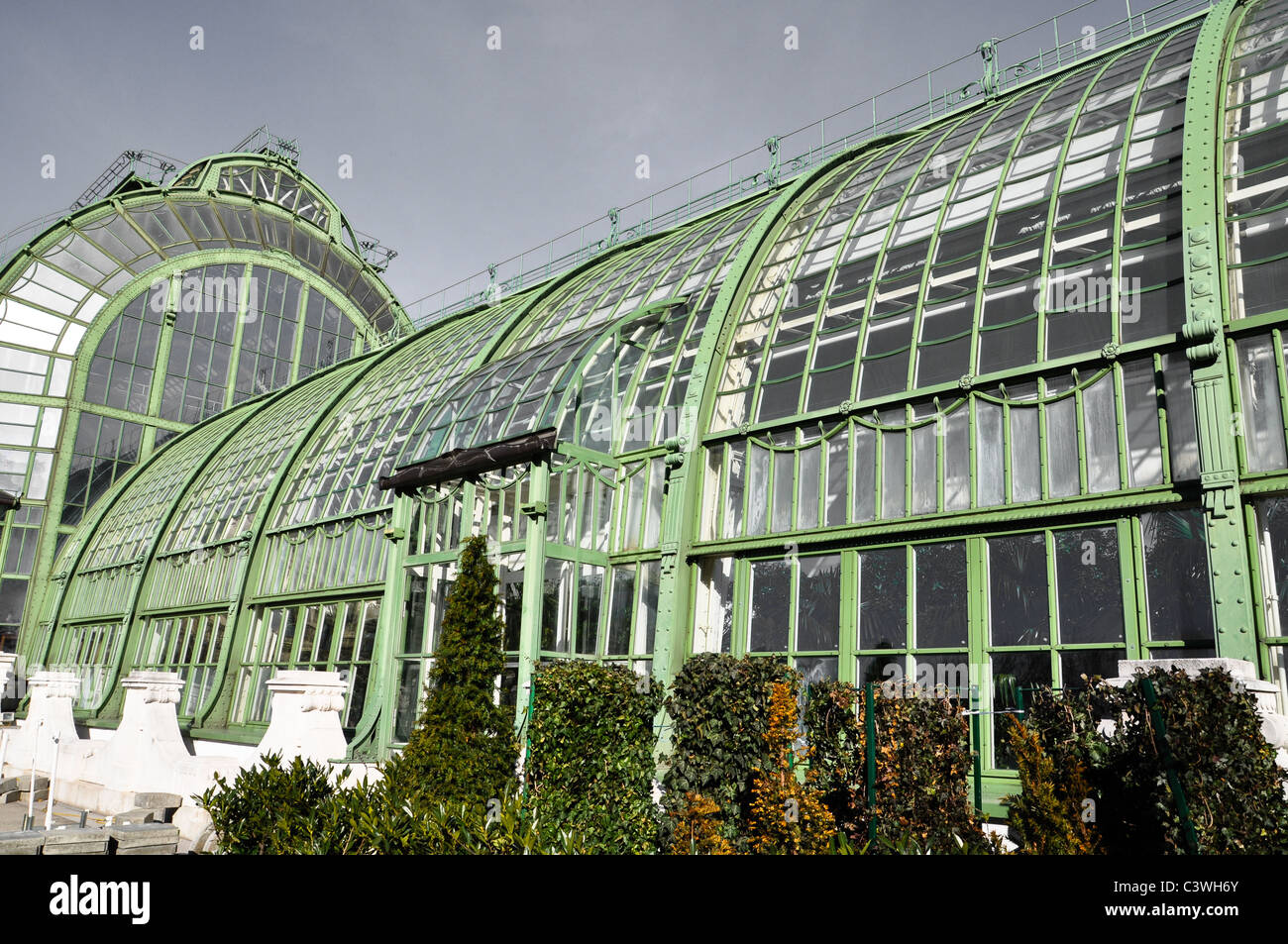 an antique greenhouse with aged steel under a grey overcast sky Stock Photo