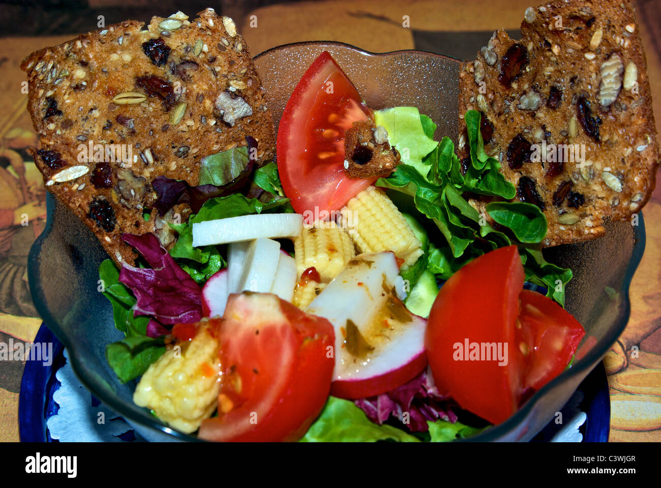 Healthy tomato baby corn butter lettuce radish red cabbage salad two slices whole grain fruit nut bread Stock Photo