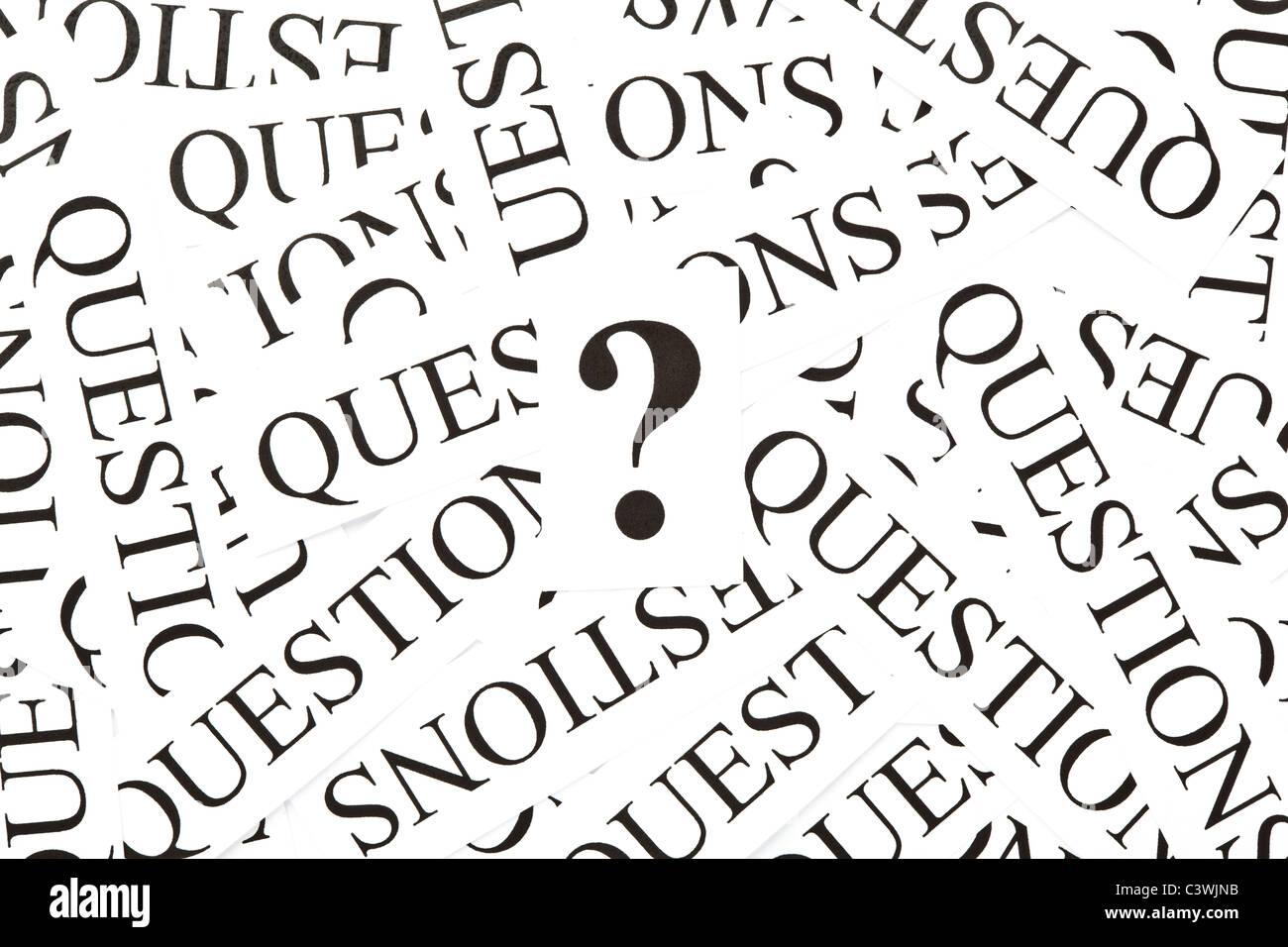 Question mark on a background of many printed paper 'Questions' Stock Photo