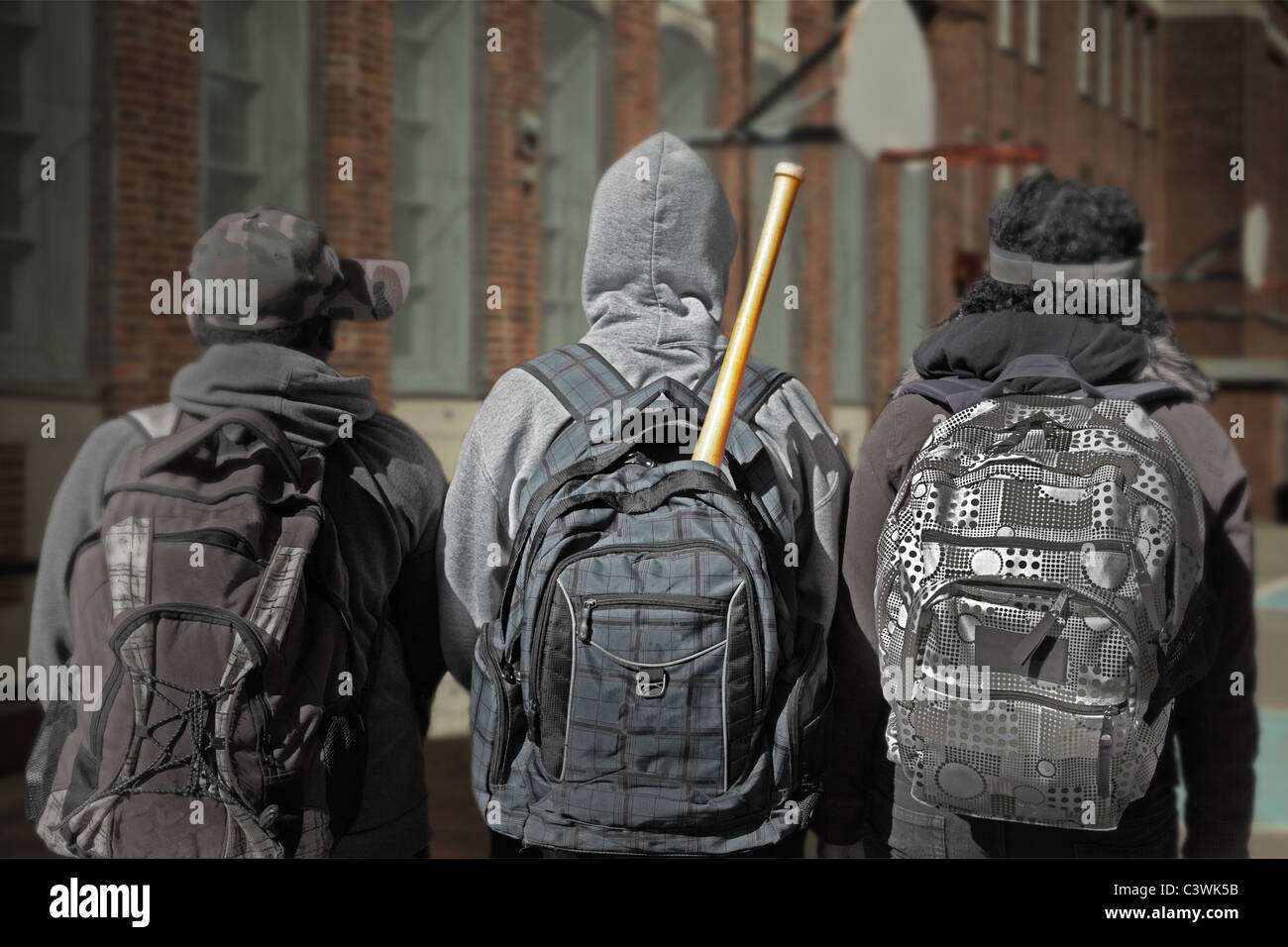 three youngsters in the schoolyard ready for bullying someone... Stock Photo