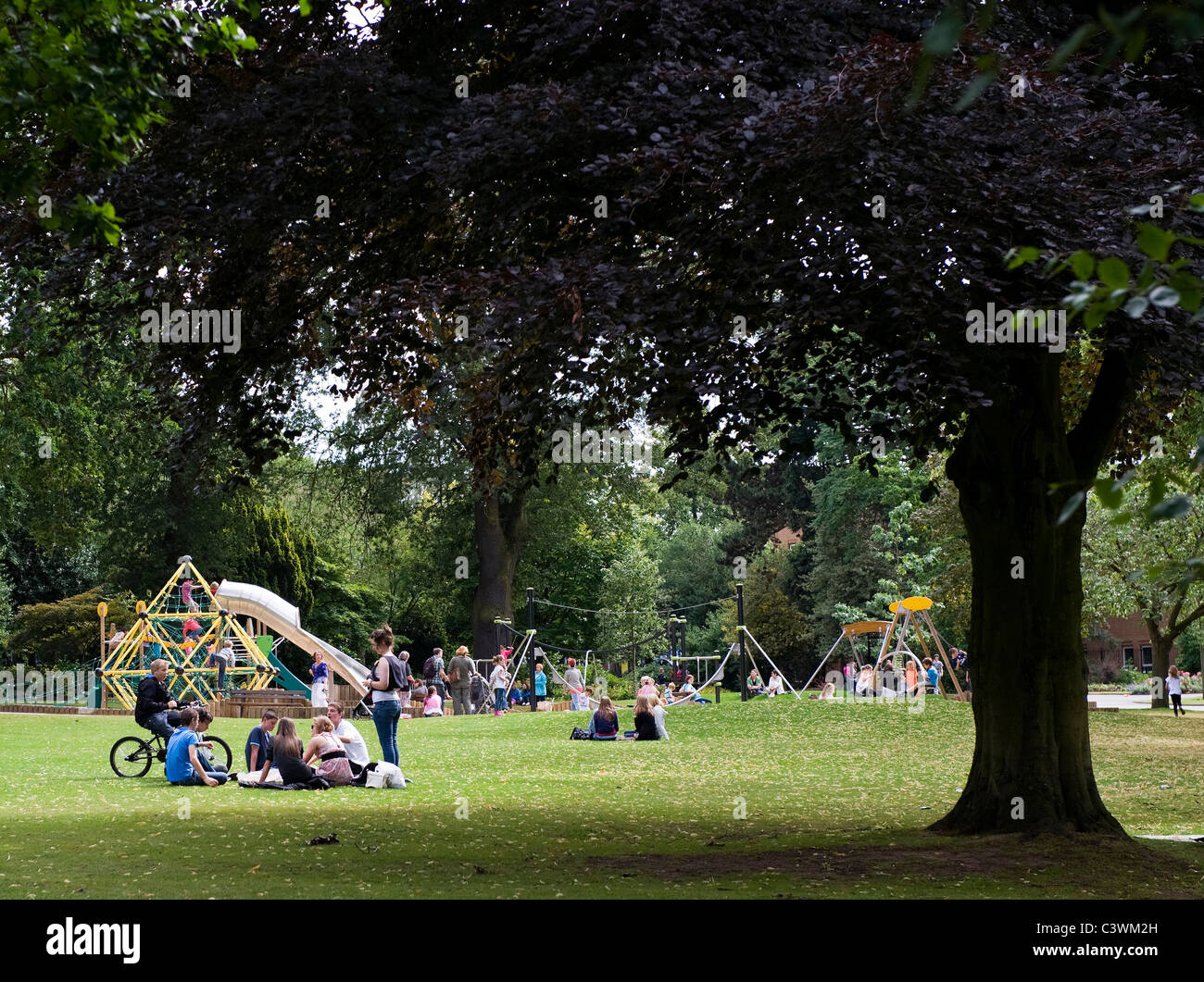 Members of the public enjoying the sunshine in Caldecott Park, Rugby, Warwickshire, England, UK Stock Photo
