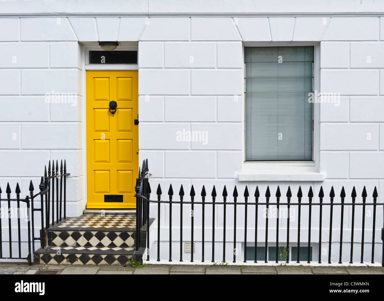 A bright yellow front door in a terrace house in Brighton Stock Photo