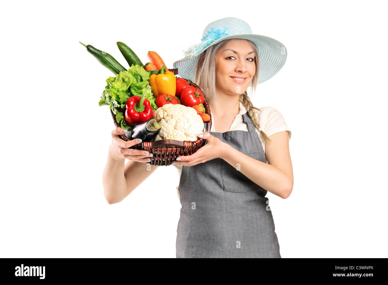 A female farmer holding a basket full of vegetables Stock Photo - Alamy