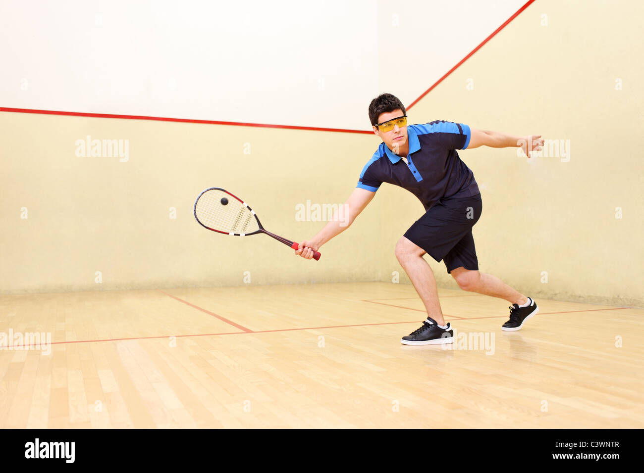 A squash player hitting a ball Stock Photo Alamy