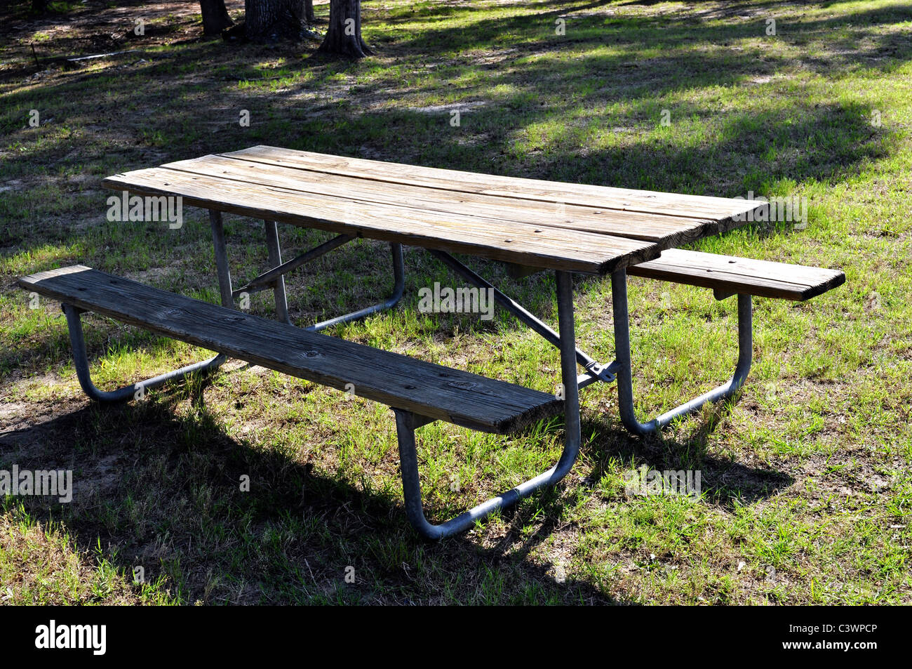 A old picnic table setting unused in the outdoors. Stock Photo