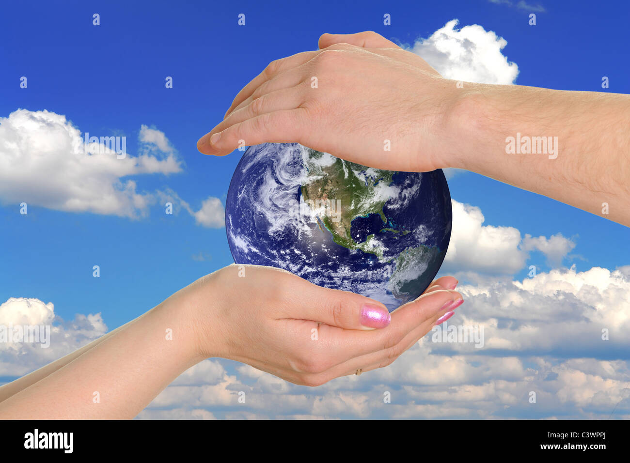 male and female hands holding the earth on background the sky Stock ...