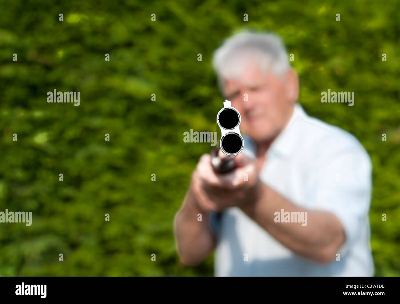 Man pointing double barreled shotgun at camera.landscape format.copy space. Stock Photo