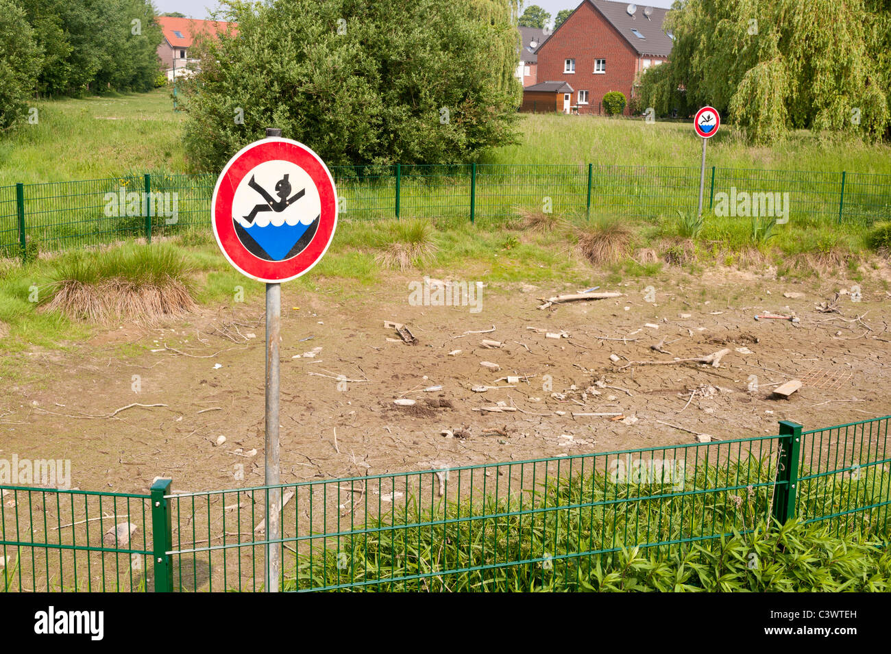 A pond is completely dry after several weeks of drought. Stock Photo