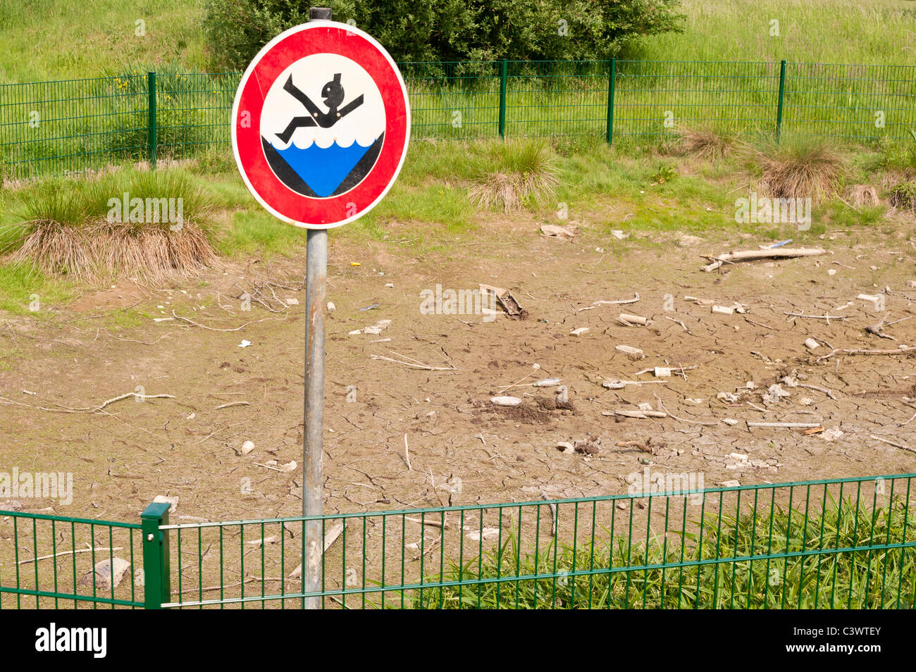 A pond is completely dry after several weeks of drought. Stock Photo