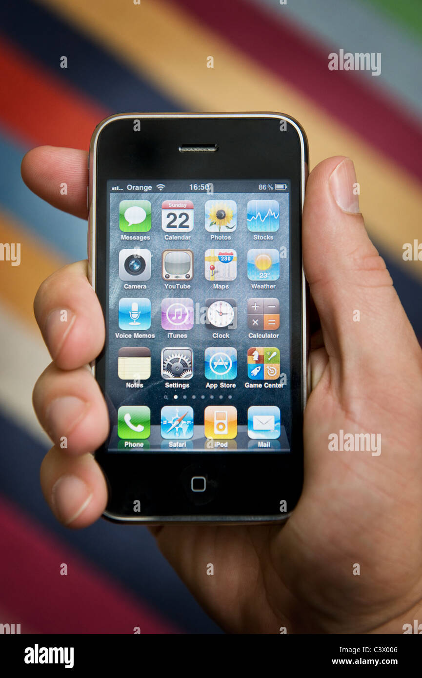 Close up of male hand holding an iPhone about select an App. (Editorial use only). Stock Photo