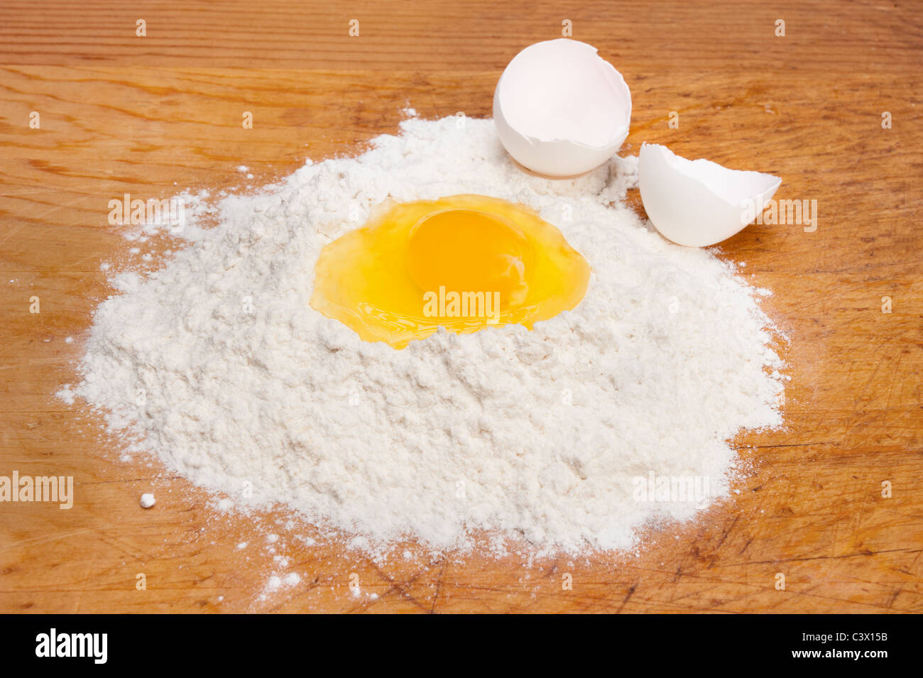 A single egg yolk in a bed of cooking flour. Stock Photo