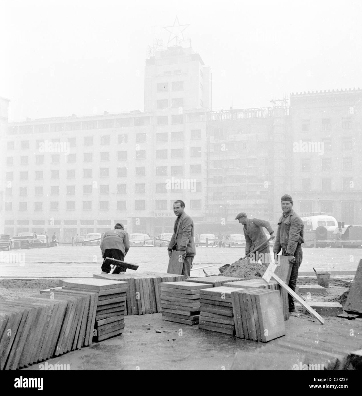 Workmen laying paving stones in a town in Yugoslavia, in this historical picture taken in the 1950s by J. Allan Cash. Stock Photo
