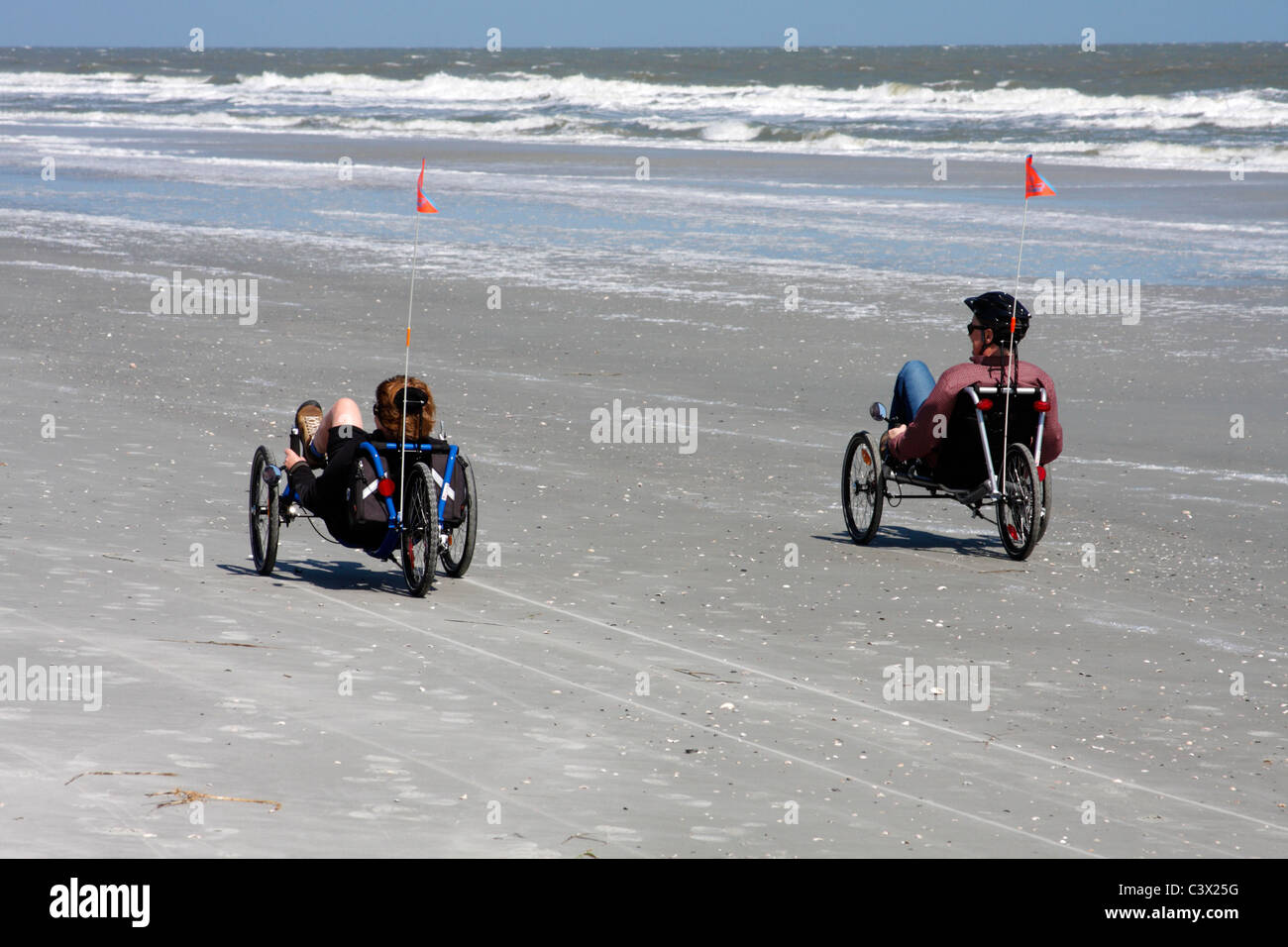 Man and woman riding trikes on the beach, Hilton Head Island, South Carolina, USA Stock Photo