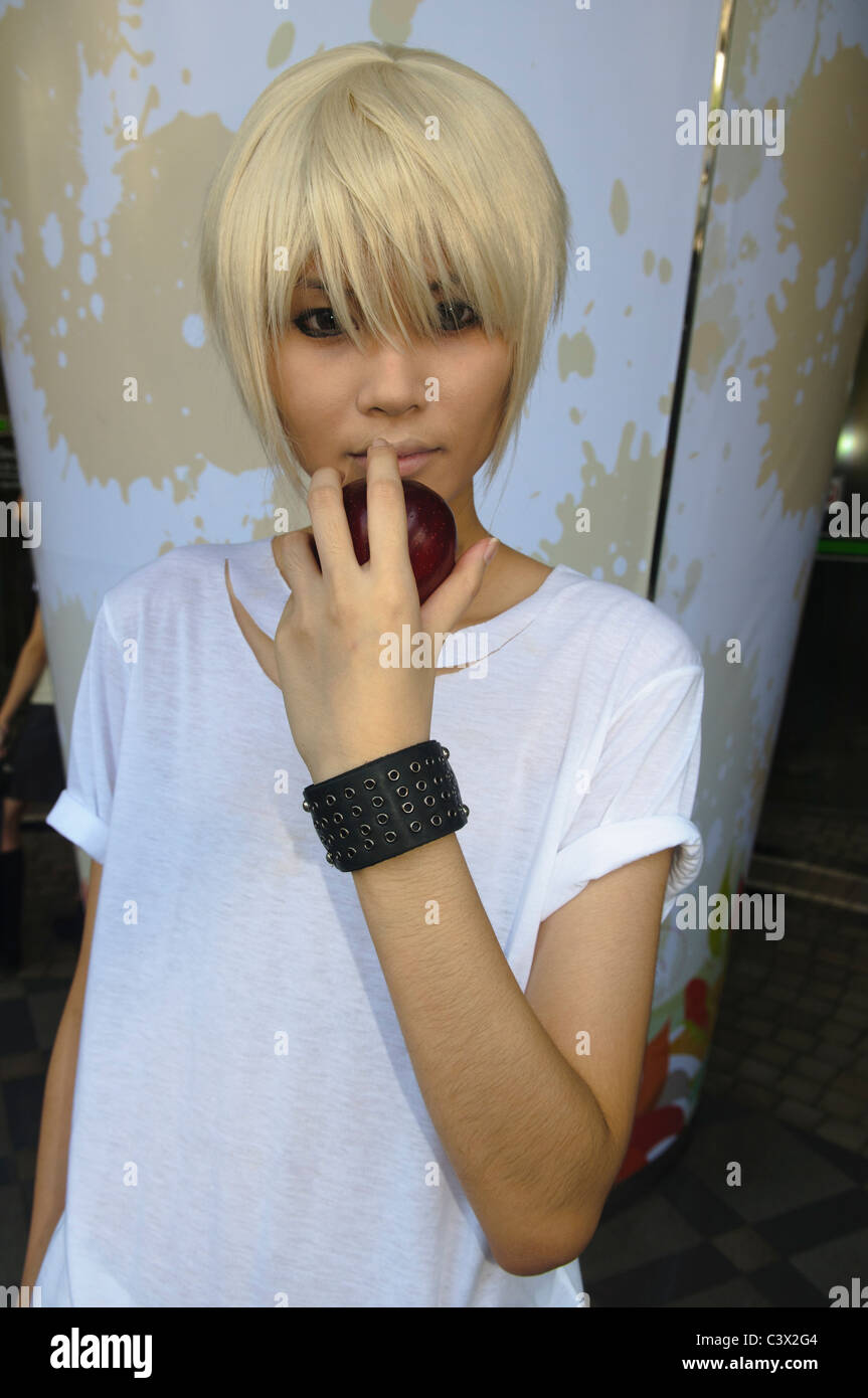 young blond Thai woman with an apple in Bangkok Stock Photo