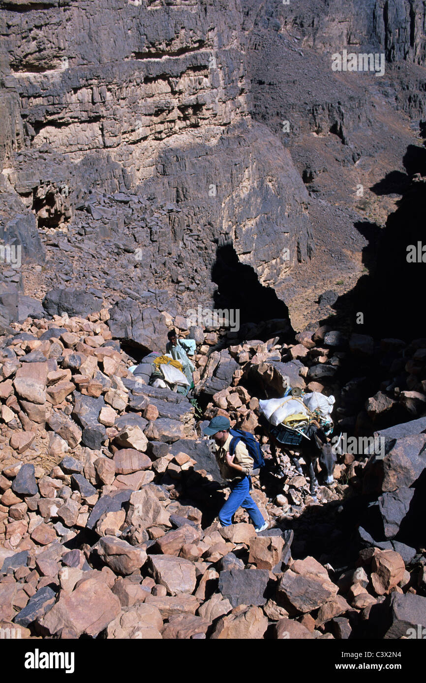 Algeria, Djanet. National Park Tassili n'Ajjer. UNESCO World Heritage site. Guides and tourists trekking with donkey Stock Photo