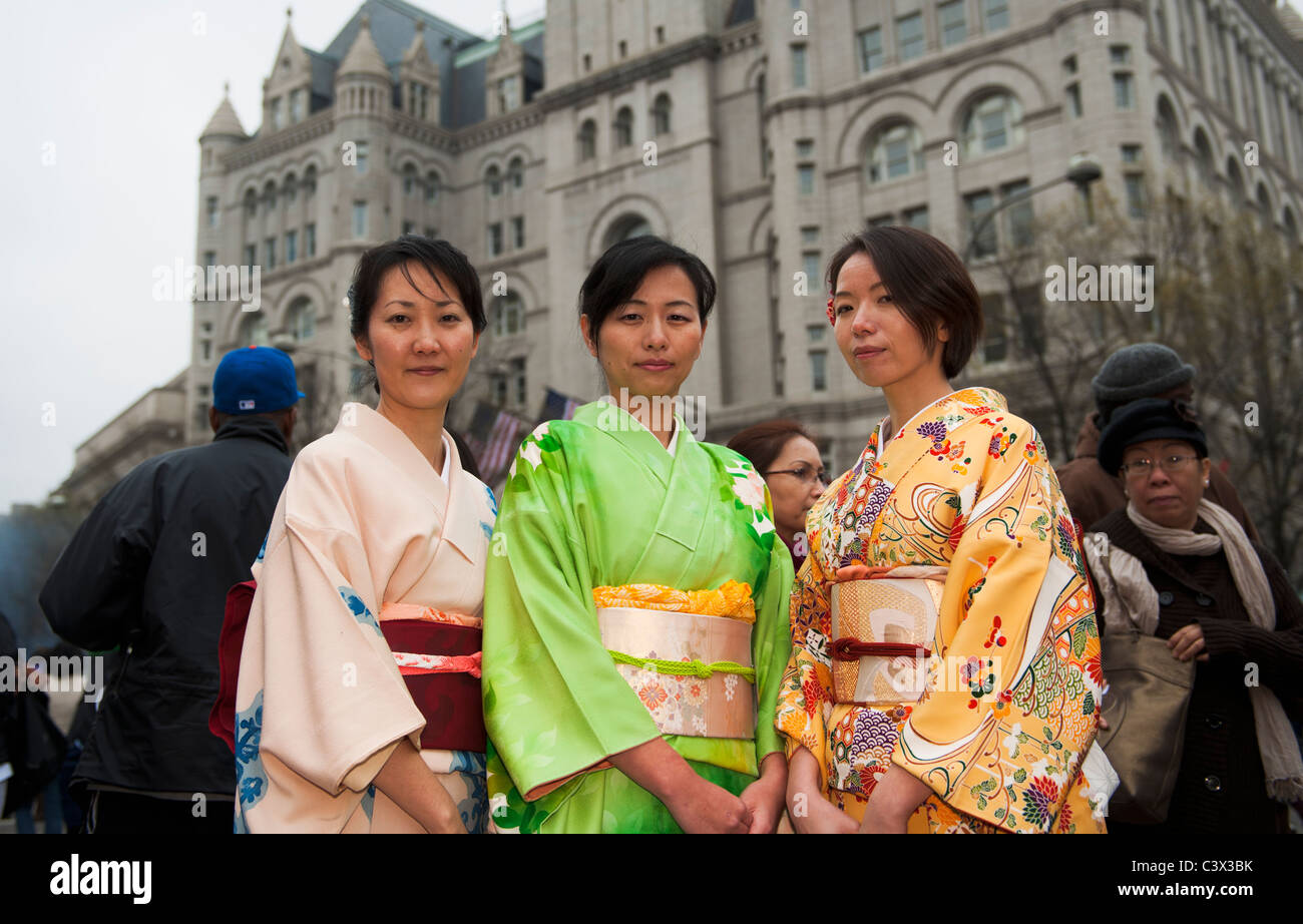 Washington DC, Three Japanese women in traditional dress with the Old Post Office Pavilion in the background. Stock Photo