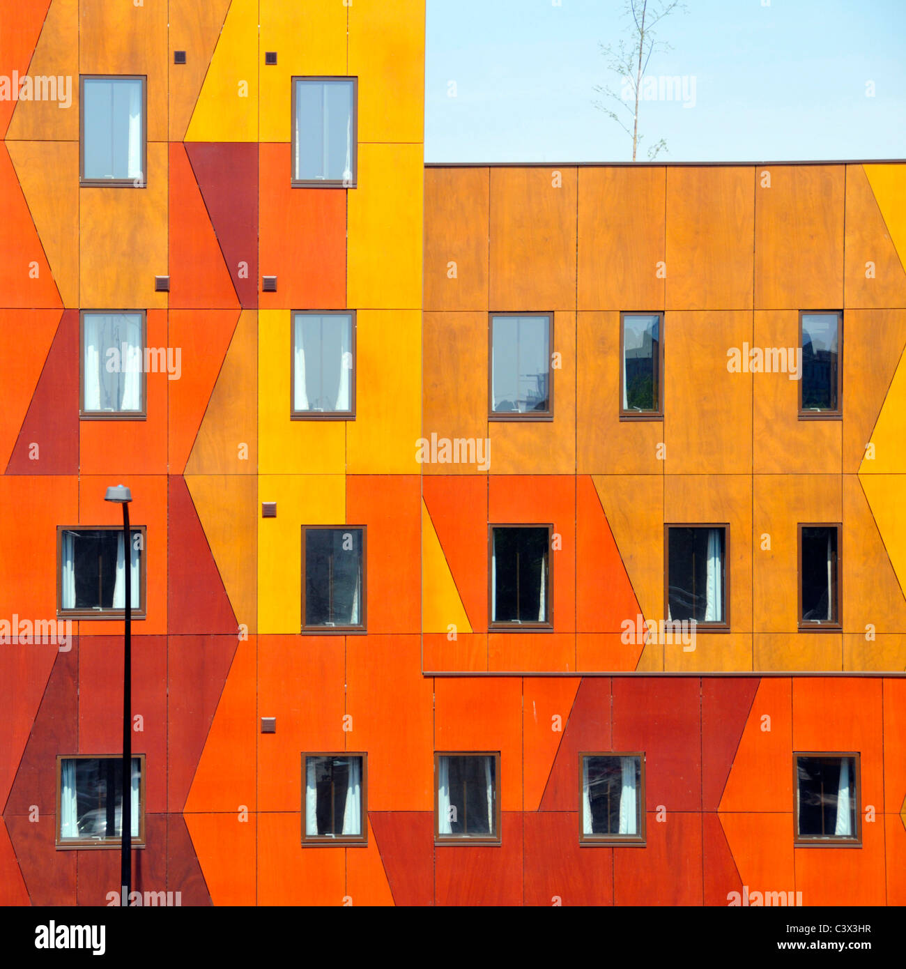 Windows in modern colourful façade of geometric shapes rectangles & triangles building cladding panels on apartment housing South London England UK Stock Photo