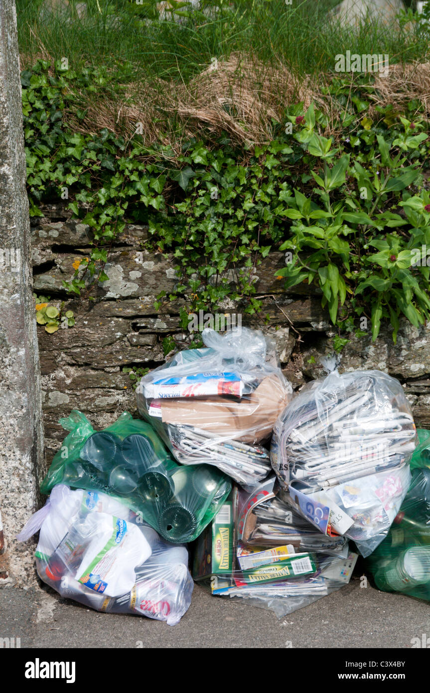 Bottles, papers and plastic containers in see-through bags awaiting collection for recycling. Stock Photo