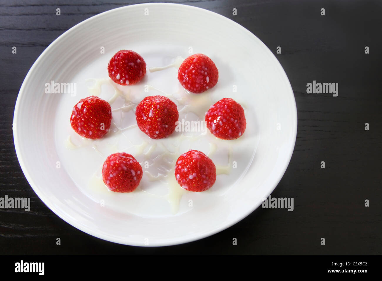 Condensed milk on strawberries Stock Photo Alamy
