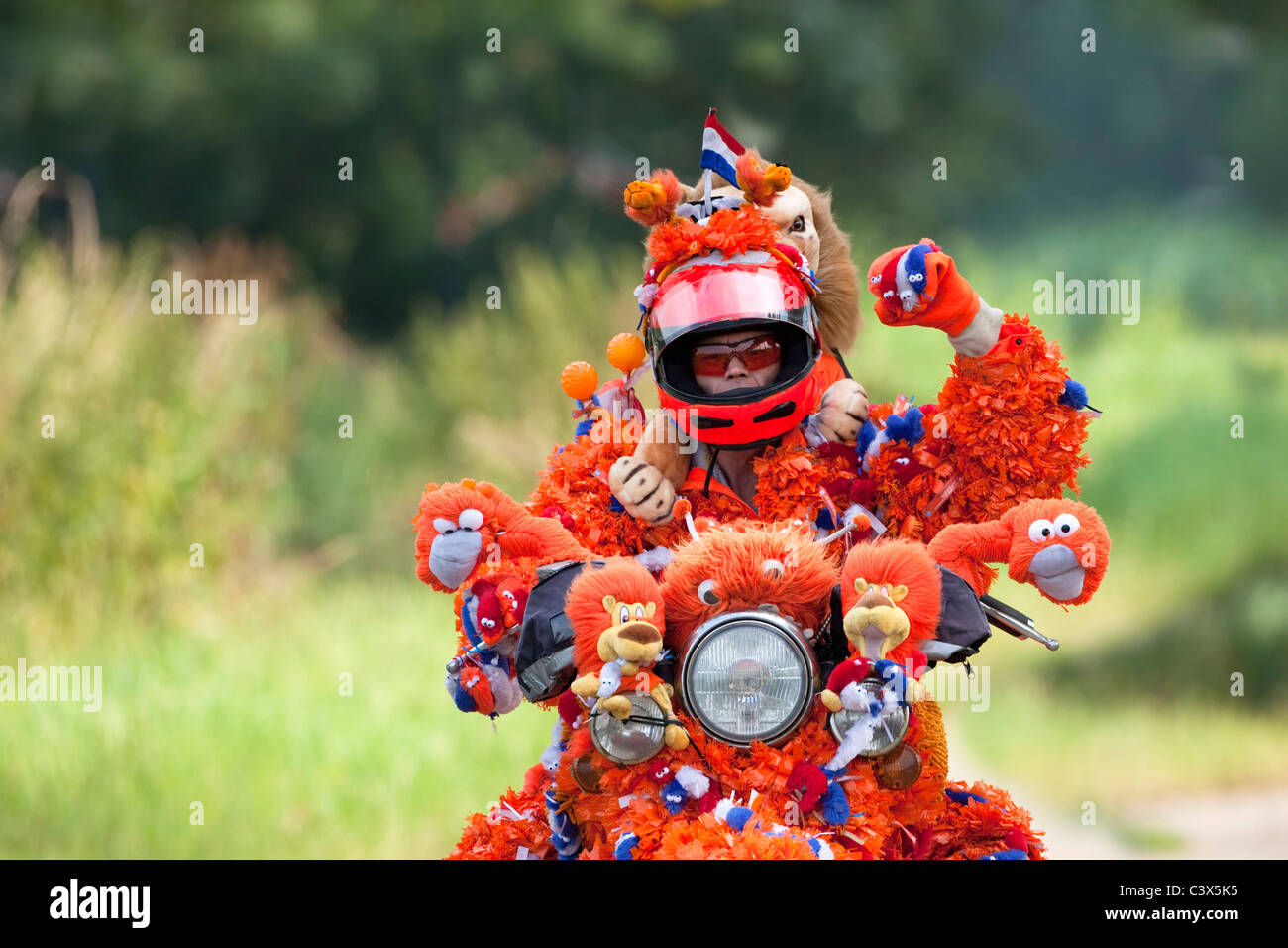 The Netherlands, World Cup Football July 2010. Motorcyclist decorated in orange, Oranje Jopie, supporter Dutch national team. Stock Photo