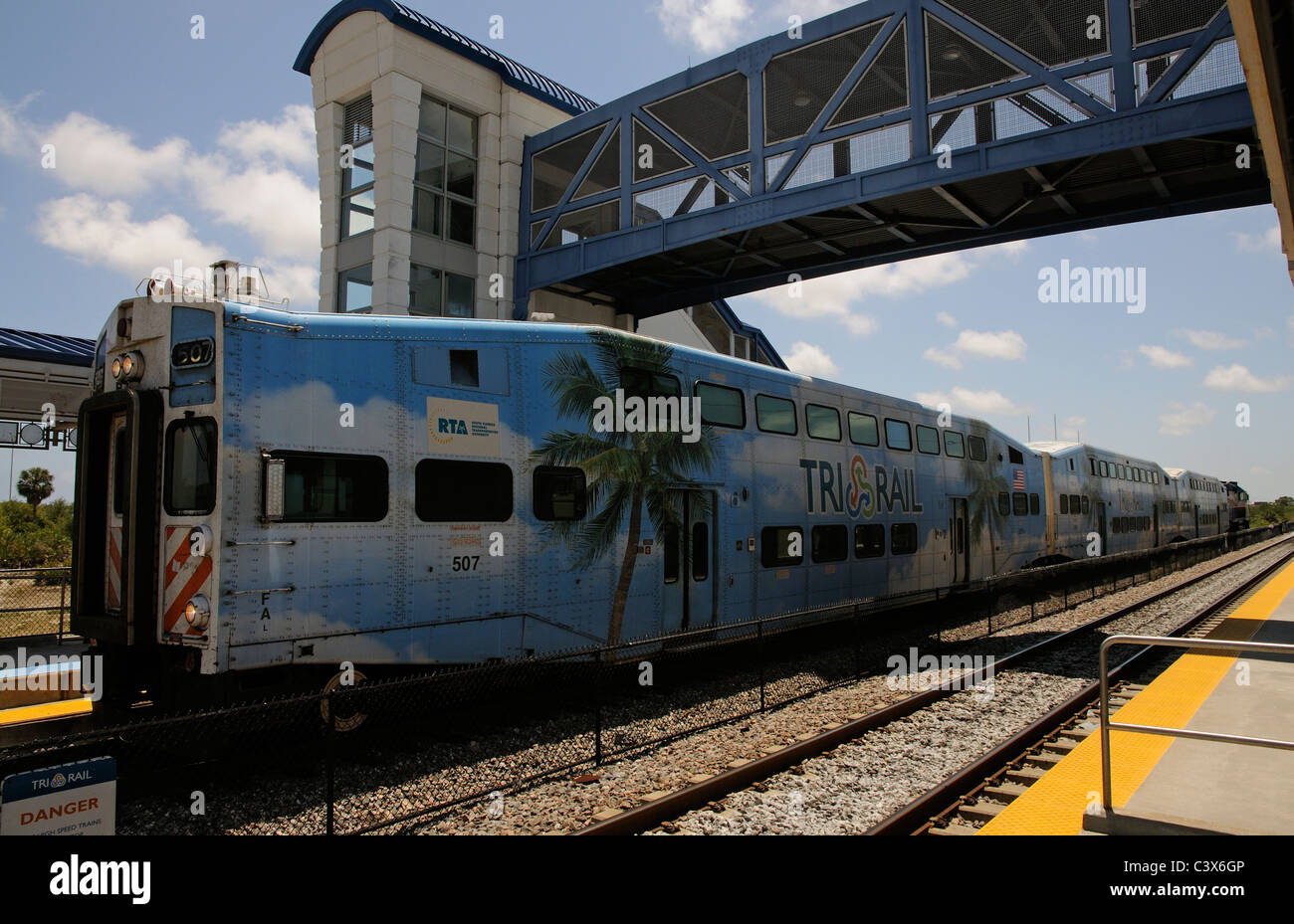 Tri Rail train painted with palm tree US flag and blue sky on the platform at Boca Raton Station