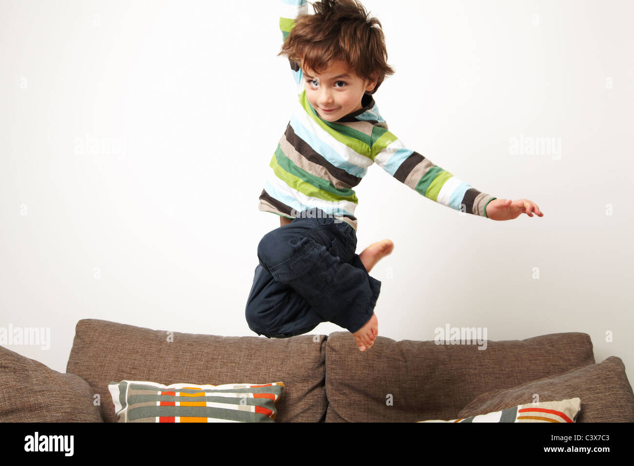 Young boy jumping on sofa Stock Photo Alamy