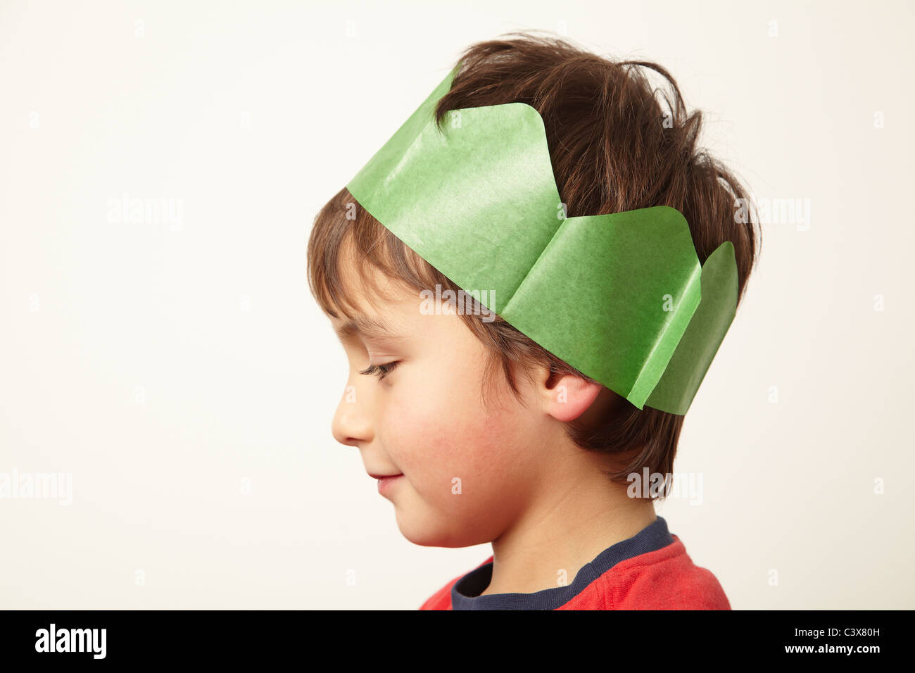 Boy wearing paper crown hat at Christmas Stock Photo