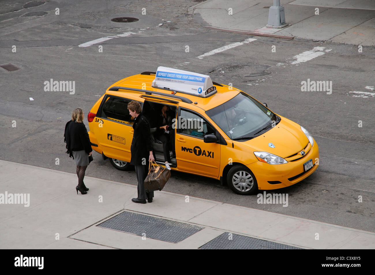 NYC taxi passengers alight from a Yellow cab in New York USA Stock Photo
